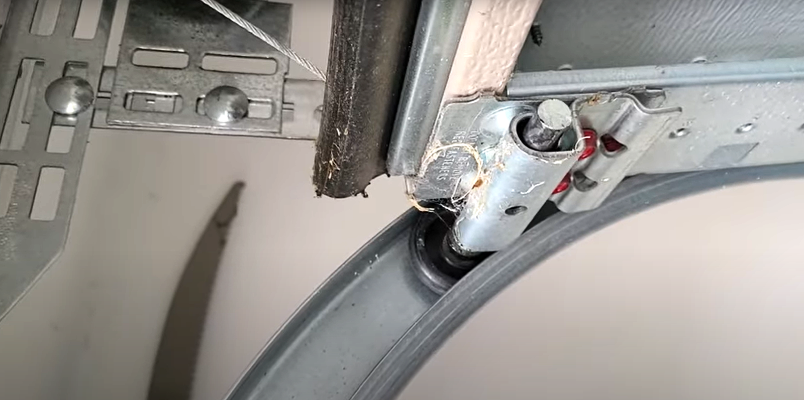 A technician performing garage door track repair on a residential garage door in Dublin, Ohio, highlighting professional repair services and attention to detail.